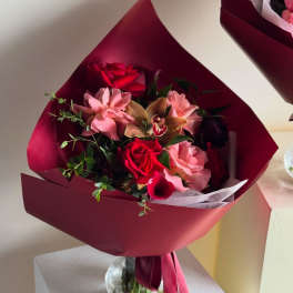 Bouquet of red and pink flowers wrapped in burgundy paper