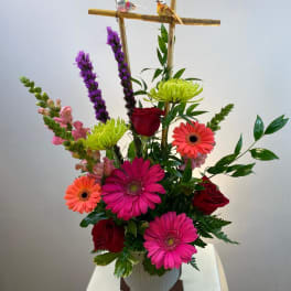 Mixed flower arrangement with gerbera daisies and roses in a vase