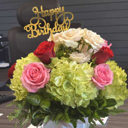 Birthday flower arrangement with roses and hydrangeas in a glass vase