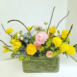 Yellow and pink mixed flower arrangement in a glass vase