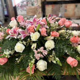 Pink and white roses with lilies in a low floral arrangement