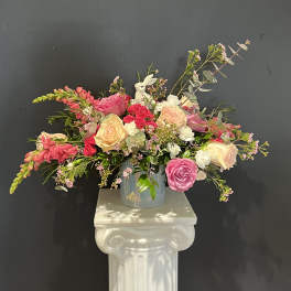Mixed pink and cream rose arrangement in a glass vase