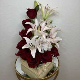 Red roses and white lilies arranged in a wooden box