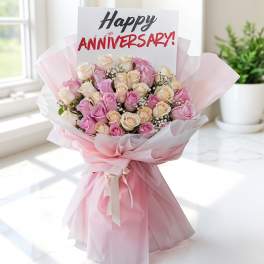 Pink and cream rose bouquet with an anniversary card