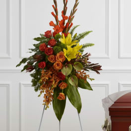 Standing floral spray with red, orange, and yellow flowers on an easel