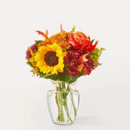 Sunflower and autumn-toned bouquet in a clear glass vase