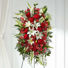 Standing floral spray with red roses, white lilies, and red filler flowers