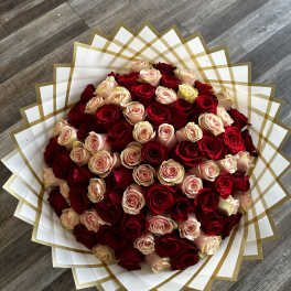 Large bouquet of red and blush roses wrapped in white and gold paper