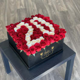 Square box of red and white roses arranged in a heart pattern
