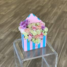 Pastel roses and chrysanthemums in a striped house-shaped box