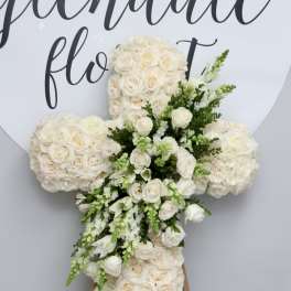 White rose cross-shaped floral arrangement on an easel