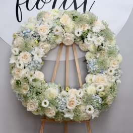 Large white floral wreath on a wooden easel