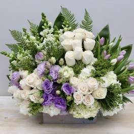 Lavender and white floral arrangement in a rectangular container