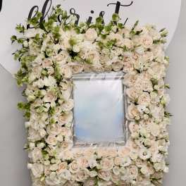 Floral frame of pale roses and white blooms around a mirror