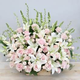 Pink roses and white lilies in a low wooden box arrangement