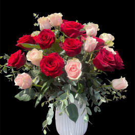 Red and blush roses arranged in a white vase