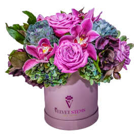Pink roses and orchids arranged in a lavender hat box