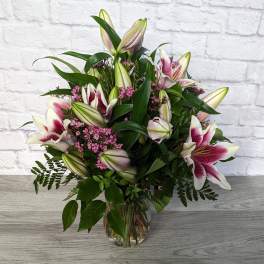 Bouquet of pink-and-white lilies in a glass vase