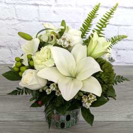White lilies and roses arranged in a mosaic vase