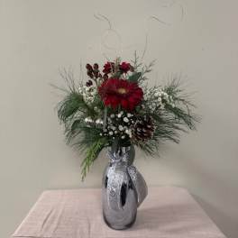Red gerbera bouquet in a silver vase with pinecones and ribbon