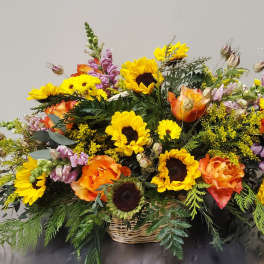 Basket arrangement of sunflowers, orange roses, and purple snapdragons