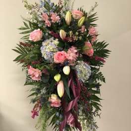 Tall standing floral spray with pink roses, lilies, and blue hydrangeas