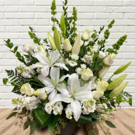 White lilies and cream roses in a low arrangement