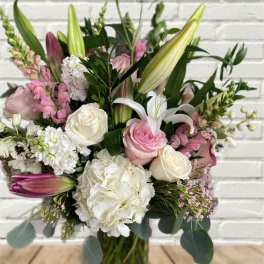 Pink and white bouquet with lilies and roses in a glass vase