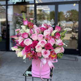 Pink and white rose bouquet in a pink hat box with ribbon