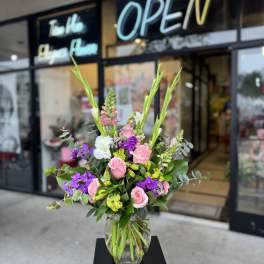 Pink and purple flower arrangement in a clear glass vase