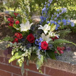 Mixed bouquet with red roses, white lilies, and blue delphinium