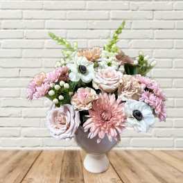 Pink and white flower arrangement in a round vase