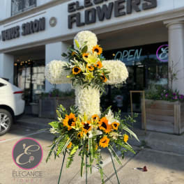 Large white floral standing cross with yellow and orange flowers
