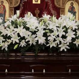 White lily arrangement on a casket in a church