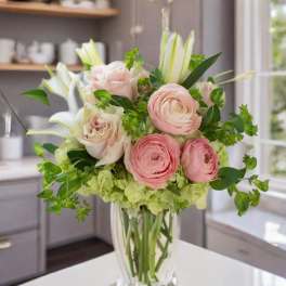 Pink roses and white lilies in a clear glass vase