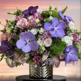 Bouquet of purple orchids and pink roses in a metallic vase