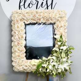 Cream rose floral frame with white calla lilies and lilies around a photo opening