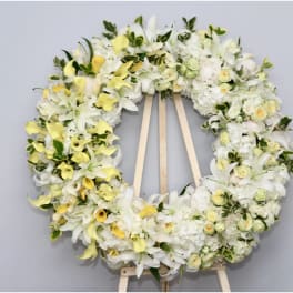 Large white and yellow floral wreath on a wooden easel