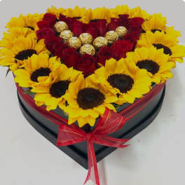 Heart-shaped box of red roses and yellow sunflowers with chocolates