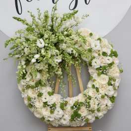 Large white floral wreath on a wooden easel