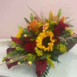Bouquet of red roses and a yellow sunflower with orange lilies