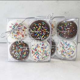 Two gift boxes of chocolate-covered cookies with colorful sprinkles