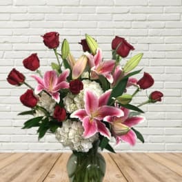 Bouquet of red roses and pink lilies in a glass vase