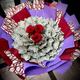 Bouquet of red roses surrounded by folded dollar bills and purple wrapping