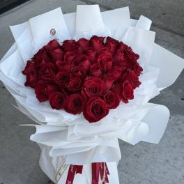 Bouquet of red roses wrapped in white paper