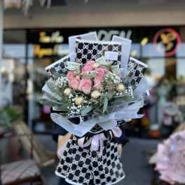 Pink rose bouquet with wrapped cash and chocolates