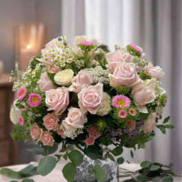 Pink roses and small daisies arranged in a square vase