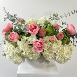 Pink peonies and white hydrangeas in a white vase