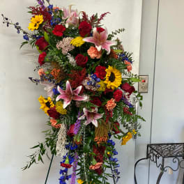 Tall standing floral spray with roses, lilies, and sunflowers