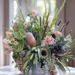 Large mixed floral arrangement in a decorative vase with pink and green blooms